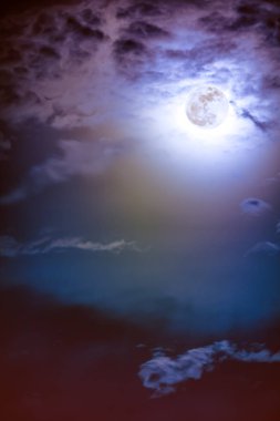 Gece gökyüzü bulutlar ve parlak dolunay ile parlak.  