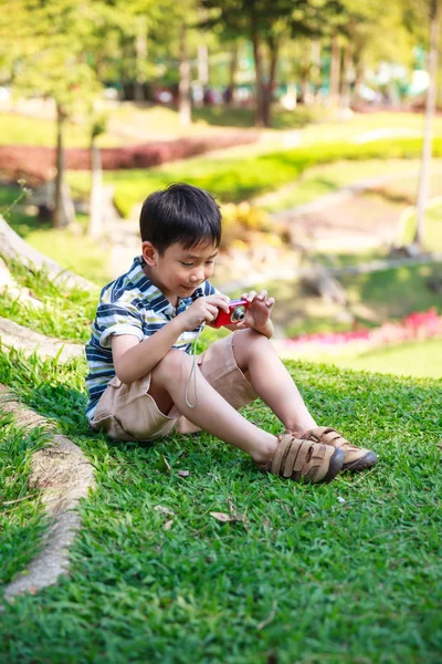 Feliz asiático chico con cámara relajante al aire libre en el día, viajar en vacaciones . —  Fotos de Stock