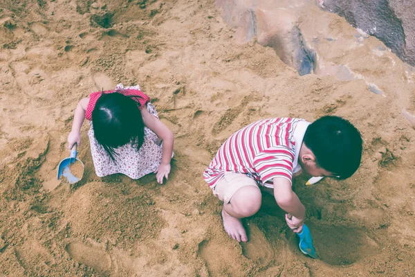 Felülnézet. Boldog bátyám és a húgom játszik a homok. Vintage hang. — Stock Fotó