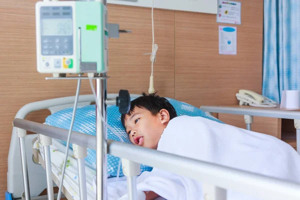 Asiatique garçon couché sur lit de maladie avec pompe à perfusion intraveineuse IV goutte à goutte — Photo