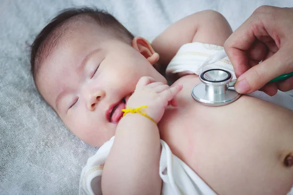 Kinderarzt untersucht Säugling. zwei monate baby asiatisch mädchen liegen — Stockfoto