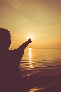 Siluet arkadan görünüm kadının relax deniz ve güneş için işaret