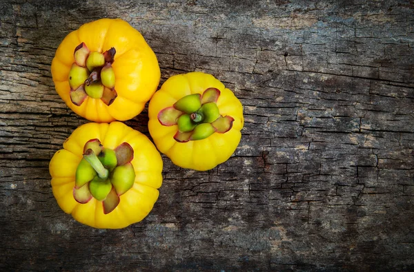 Ovanifrån. Garcinia cambogia färsk frukt på trä bakgrund. — Stockfoto