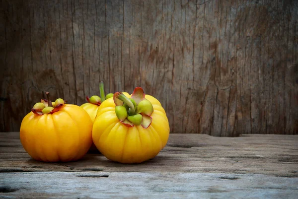 Garcinia cambogia fruta sobre fundo de madeira . — Fotografia de Stock