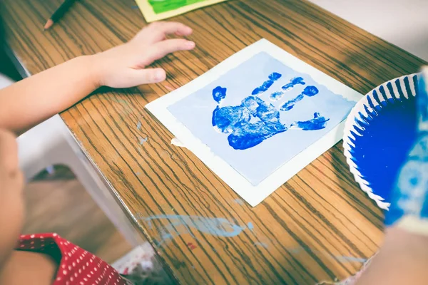 Un enfant peint sa paume sur un cours d'art. Concept d'éducation et d'apprentissage — Photo