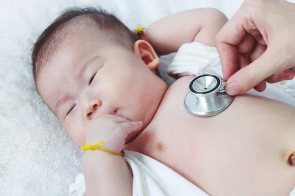 Kinderarzt untersucht Säugling. zwei monate baby asiatisch mädchen liegen — Stockfoto