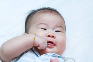 Yatakta yatan Closeup mutlu gülümseyen bir çocuk. Bebek kız.