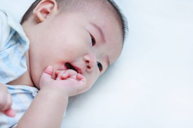 Yatakta yatan Closeup mutlu gülümseyen bir çocuk. Bebek kız.