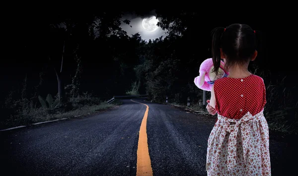 Вид ззаду молода дівчина стоїть на дорозі в лісі. Самотній — стокове фото
