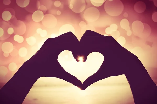 Valentine de achtergrond. Silhouet van menselijke hand in hart vorm tonen liefde — Stockfoto
