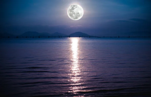 Romántico paisaje con luna llena en el mar a la noche. Reflexión de la luna en el agua . — Foto de Stock