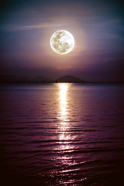 Romantic scenic with full moon on sea to night. Reflection of moon in water. 