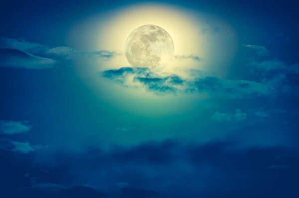 Background of nighttime sky with cloud and full moon with shiny. Natural beauty at night with beautiful moon behind cloud. Cross process and vintage effect tone. The moon were NOT furnished by NASA.