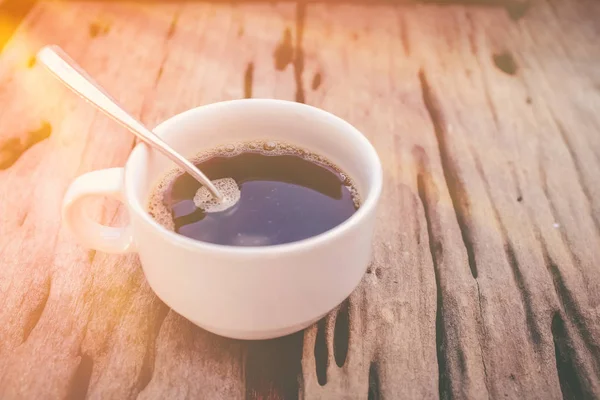 Hot coffee on old wooden background with sunlight. Vintage picture style. — Stock Photo, Image