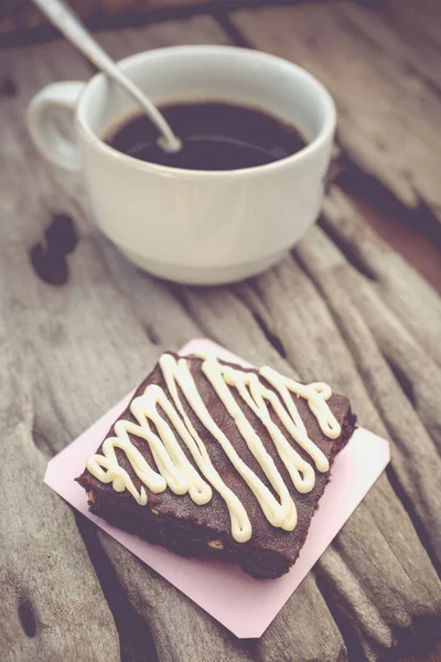 Pastel de chocolate brownie y café caliente sobre fondo de madera vieja . —  Fotos de Stock