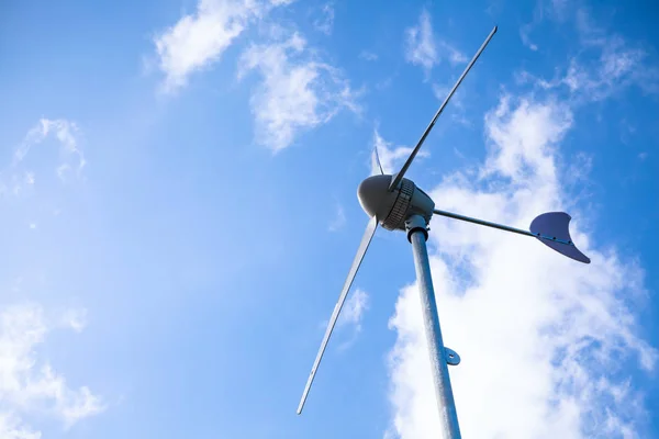 Blick von unten auf eine Windmühle zur Stromerzeugung. Draußen bei hellem Sonnenlicht am Tag. — Stockfoto