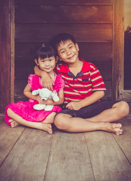 Aziatische broer zetten iemands arm rond sister's schouder en glimlachend gelukkig samen. — Stockfoto