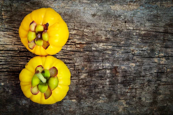 Ovanifrån. Garcinia cambogia färsk frukt på trä bakgrund. — Stockfoto