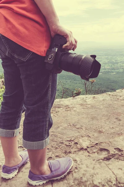 Vrouw met digital camera bij oogpunt op berg. — Stockfoto
