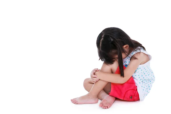 Sad asian girl barefoot sitting on floor with copy space. Isolated on white background. — Stock Photo, Image