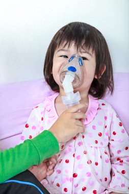 Asyalı kız kardeşi tarafından maskesi Hastanesi tarafından inhalasyon ile yardımcı solunum yolu hastalığı olan.