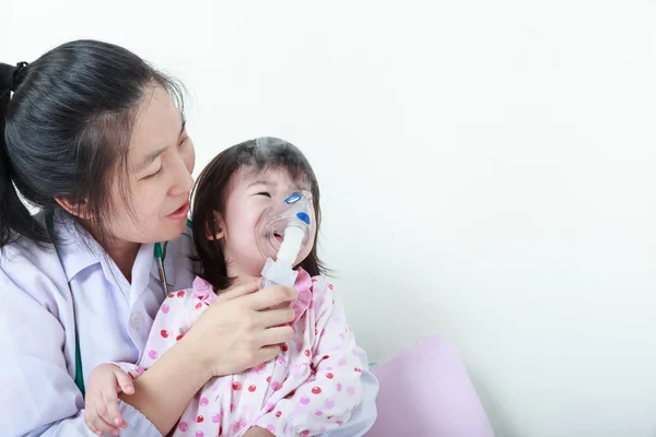 Menina asiática com doença respiratória ajudada pelo médico com inalador . — Fotografia de Stock