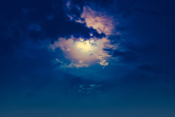 Attractive photo of background nighttime sky with clouds and bright full moon with shiny. Nightly sky with beautiful full moon behind cloud. Outdoors at night. The moon were NOT furnished by NASA.