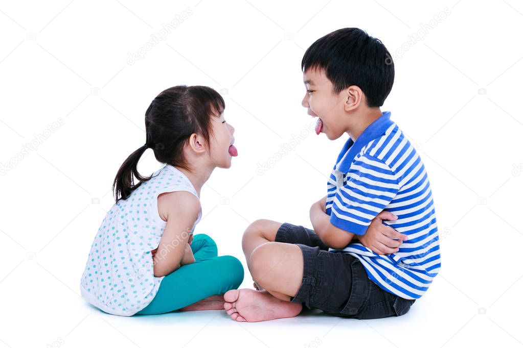 Bad behavior. Asian children sticking out tongues and mocking each other.