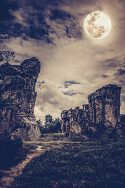 Kayalar ile bulutlar ve güzel dolunayda gece gökyüzü karşı.
