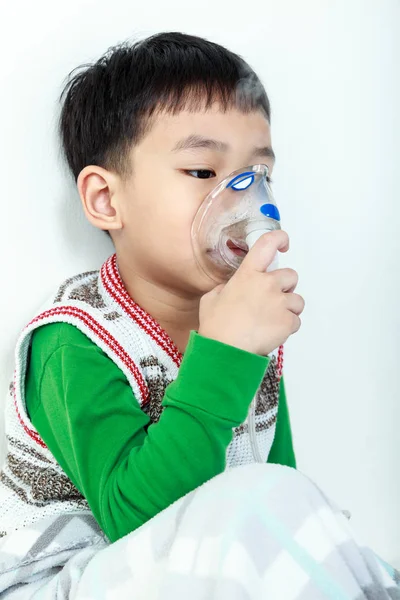 Niño asiático sostiene un inhalador de vapor máscara para el tratamiento del asma . —  Fotos de Stock