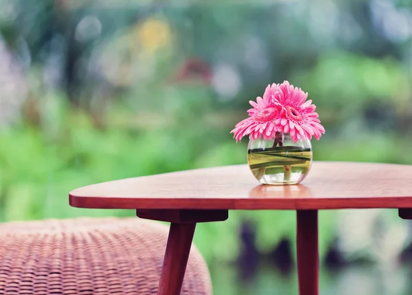 Pink flowers in vase on table in the garden. Vintage effect tone — Stock Photo, Image