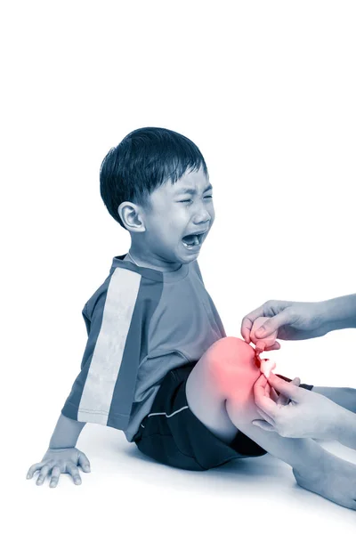 Asiatischer Junge mit Wunde am Bein weint. Krankenschwester leistet Erste Hilfe am Knie. — Stockfoto