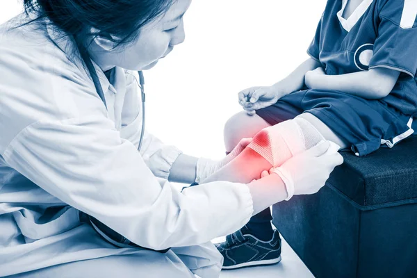 Lesão desportiva. Médico faz bandagem no joelho paciente, no fundo branco — Fotografia de Stock