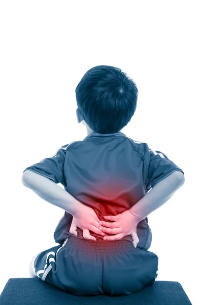 Dolor de espalda. Niño frotando los músculos de su espalda baja. Aislado sobre fondo blanco . — Foto de Stock