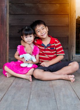 Asya kardeşim kişinin kol kız kardeşinin omuz ve birlikte mutlu gülümseyerek çevresinde koymak. Hakkında sevgi dolu ve eş olan bağ kavramı