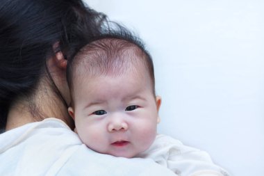 Anne ve bebek, annesinin omzuna dinlenme güzel Asyalı kız