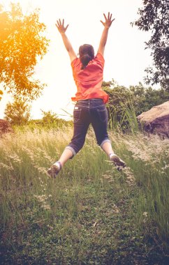 Zıplama, açık havada kadın arkadan görünüm. Vintage sesi. Mutluluk ve özgürlük kavramı. 