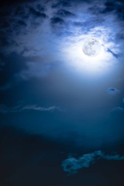 Gece gökyüzü bulutlar ve parlak dolunay ile parlak.  