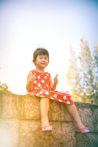 Glückliche asiatische Mädchen mit klopfen nach oben und entspannen im Freien am Tag. Reise in den Urlaub. — Stockfoto