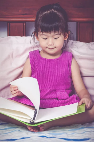 Chica asiática leyendo un libro. Concepto educativo. Efecto tono Vintage — Foto de Stock