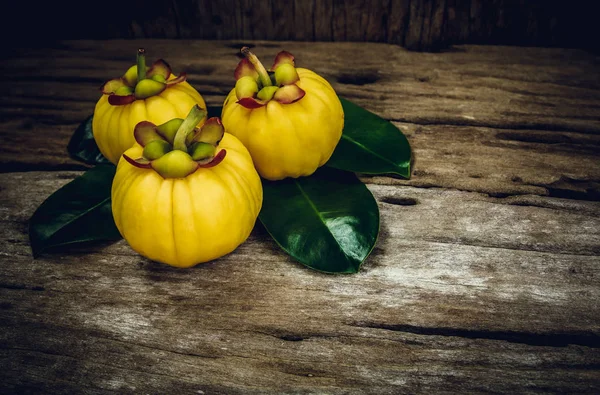 Garcinia cambogia fruta fresca sobre fundo de madeira. Frutas para dieta — Fotografia de Stock