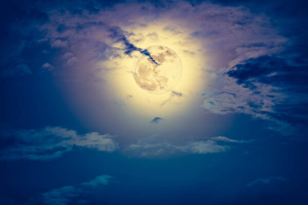 Background of nighttime sky with cloud and bright full moon with shiny. Natural beauty at night with beautiful full moon behind cloud. Vintage effect tone. The moon were NOT furnished by NASA.