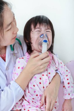 Asyalı kız doktor tarafından yardımcı solunum yolu hastalığı olması. Bronşit ve ağlayan çocuktum.