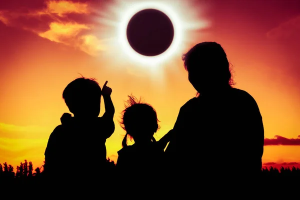 Doğal bir olgu. Aile oturan ve birlikte rahatlatıcı siluet arkadan görünüm.