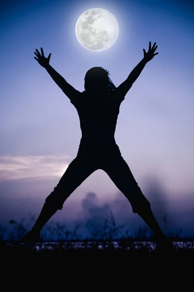 Silhouette back view of woman enjoying and jumping at riverside. — Stock Photo, Image