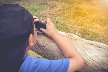 Asyalı çocuk açık havada gün zamanında rahatlatıcı görünümünü top, tatil seyahat.