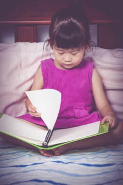 O bir kitap okurken uyku kız yorgun ve bıkkın. Eğitim kavramı.