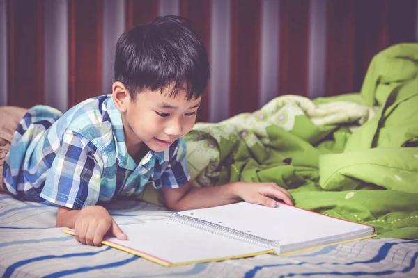 Un chico asiático leyendo un libro. Concepto educativo. Tono vintage . — Foto de Stock