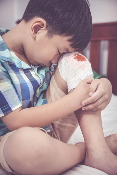 Kind verletzt. Wunde am Knie des Kindes mit Verband. Vintage-Ton. — Stockfoto