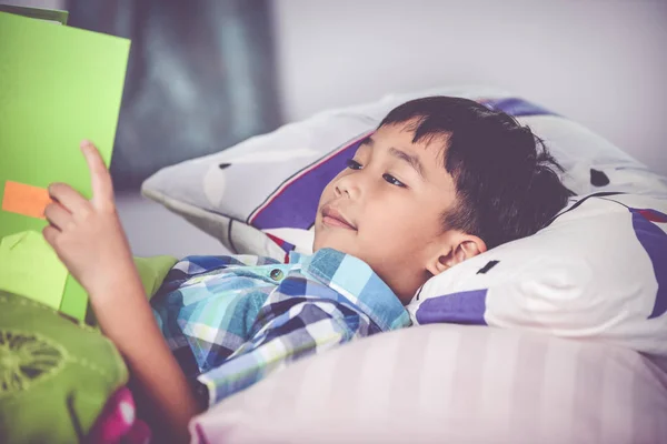 Un chico asiático leyendo un libro. Concepto educativo. Efecto tono Vintage — Foto de Stock